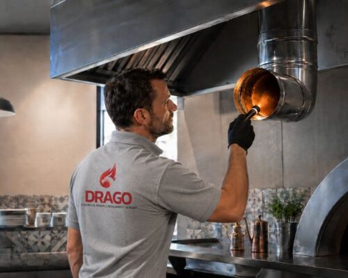 Tecnico Drago Group con polo grigia durante l’ispezione della canna fumaria in una cucina professionale